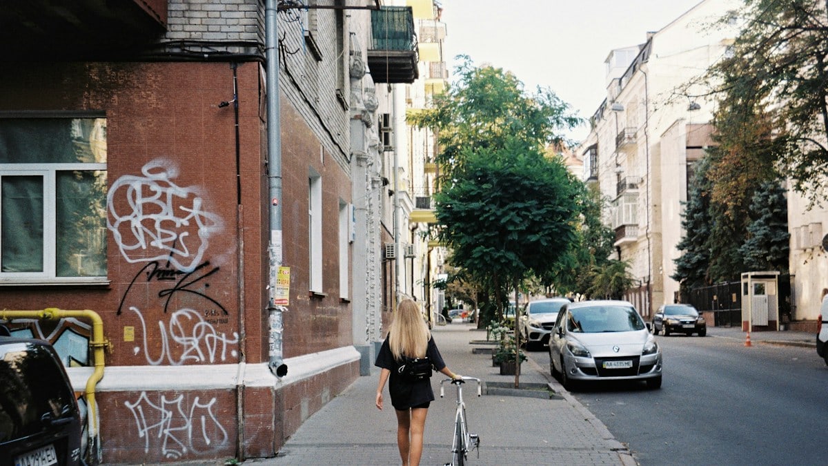 woman in black shirt and black shorts walking on sidewalk during daytime